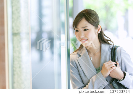 一位女商人正看著商店櫥窗。 137333734