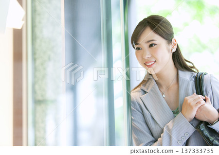 Businesswoman looking at a shop window 137333735