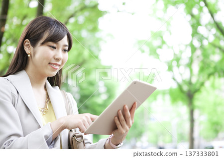 Business woman operating a tablet PC Business woman operating a tablet PC 137333801