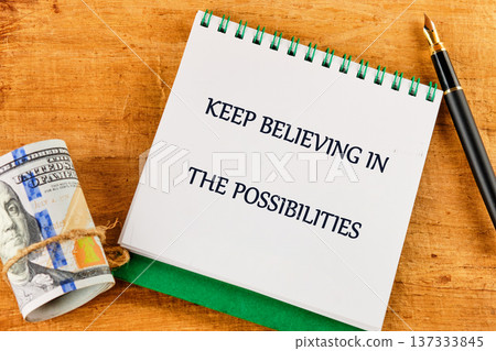 A spiral notepad boldly displays an uplifting message encouraging belief in possibilities 137333845