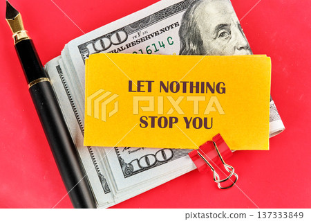 Powerful message on a bold yellow note, surrounded by stacks of hundred dollar bills a fountain pen, on a vivid red background Powerful message on a bold yellow note, surrounded by stacks of hundred dollar bills a fountain pen, on a vivid red background 137333849