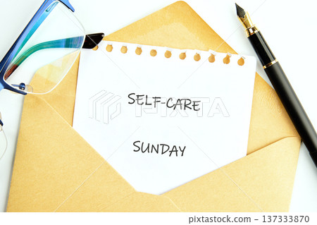 A white notepad paper tucked inside a warm brown envelope declares SELF-CARE SUNDAY 137333870