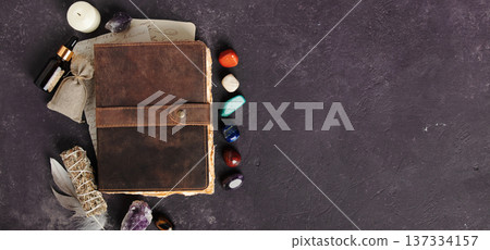Rustic Leather Journal with Healing Crystals on Dark Background banner 137334157
