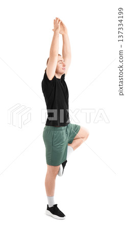 Sporty young man practicing yoga in Tree Pose (Vrksasana) with arms raised and eyes closed, isolated on white background. High quality photo 137334199