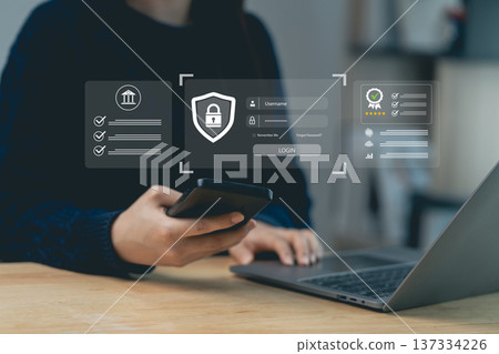 Hands using smartphone and laptop with secure login hologram interface. Cyber security, data protection and authentication concept. Hands using smartphone and laptop with secure login hologram interface. Cyber security, data protection and authentication concept. 137334226
