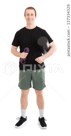 Smiling athletic man holding a foam roller and resistance band. Full length studio shot of a fitness trainer with equipment isolated on white background. High quality photo Smiling athletic man holding a foam roller and resistance band. Full length studio shot of a fitness trainer with equipment isolated on white background. High quality photo 137334329