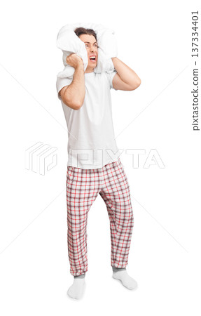Angry young man in pajamas covering his ears with a pillow and screaming due to loud noise. Isolated full body shot on white background. High quality photo Angry young man in pajamas covering his ears with a pillow and screaming due to loud noise. Isolated full body shot on white background. High quality photo 137334401
