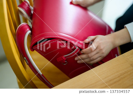 Children's hands preparing their school bags Children's hands preparing their school bags 137334557