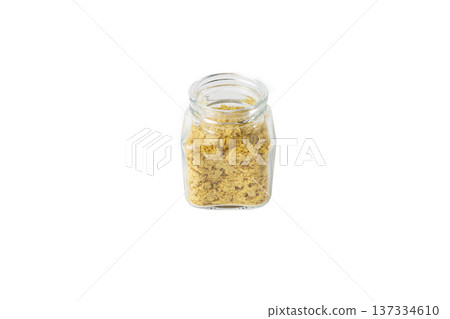 Savoury vegan yeast flakes in a glass jar isolated on white background. Savoury vegan yeast flakes in a glass jar isolated on white background. 137334610