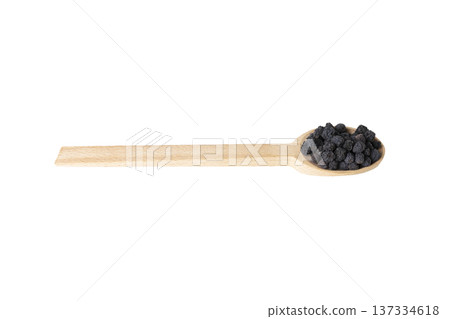 Dried Aronia or black chokeberry - Aronia melanocarpa in latin on wooden spoon isolated on white background. 137334618