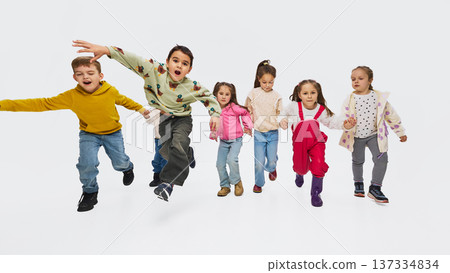 Children jumping forward wearing colorful mid season kids fashion outfits in studio Children jumping forward wearing colorful mid season kids fashion outfits in studio 137334834