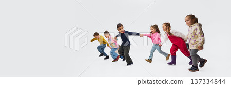 Children walking holding hands wearing colorful mid season kids fashion outfits in studio. Banner Children walking holding hands wearing colorful mid season kids fashion outfits in studio. Banner 137334844