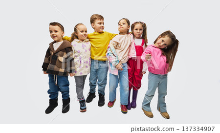 Group of children standing together wearing colorful mid season kids fashion outfits in studio Group of children standing together wearing colorful mid season kids fashion outfits in studio 137334907