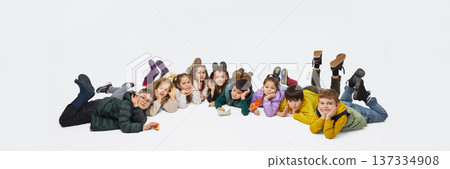 Group of children lying on floor in row wearing mid season kids fashion outfits in studio. Banner Group of children lying on floor in row wearing mid season kids fashion outfits in studio. Banner 137334908