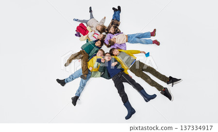 Children lying in circle on floor wearing colorful mid season kids fashion outfits in studio. Children lying in circle on floor wearing colorful mid season kids fashion outfits in studio. 137334917