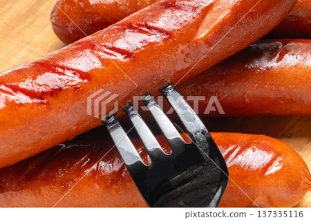 Appetizing grilled sausages on a cutting board close-up Appetizing grilled sausages on a cutting board close-up 137335116