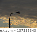 A street lamp on a city street against a background of Dramatic Cloudscape Of Wide Sky with delicate beige and delicate gray stratospheric clouds in a blue sky. Altocumulus 137335343