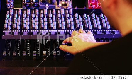 Sound Engineer Adjusts Faders, Hand Moves Controls. Music Production, Modern Studio, Creative Process, Concert Setup. Sound Engineer Adjusts Faders, Hand Moves Controls. Music Production, Modern Studio, Creative Process, Concert Setup. 137335574