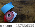 Red and blue kinesiology tape strips on wooden background 137336335