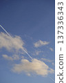 Airplane trail in the blue sky, white clouds on a sunny day 137336343