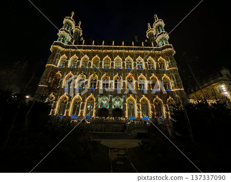 Night view of Leuven town hall decorated for christmas with outdoor market 137337090