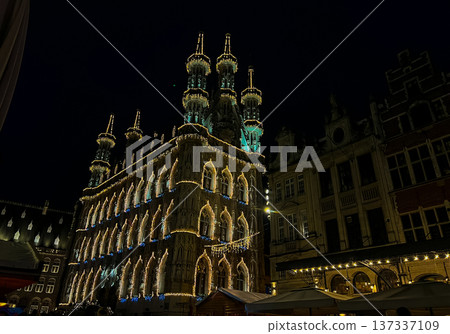 Night view of Leuven town hall decorated for christmas with outdoor market 137337109