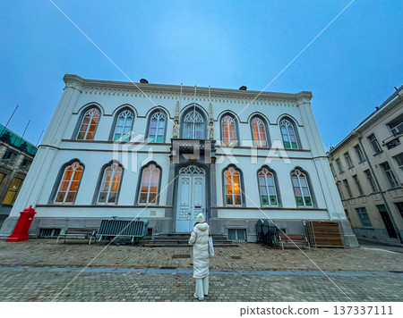 Elegant white gothic-style building facade in Ghent with woman outside 137337111