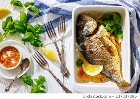 Baked whole dorada fish with lemon and basil Baked whole dorada fish with lemon and basil 137337380