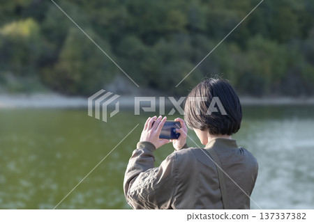 一名年輕男子正在拍攝一座墓塚。 137337382