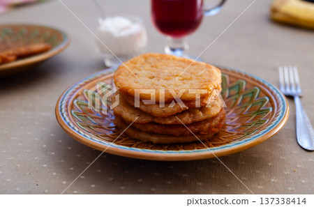 Stacked Potato Pancakes on Rustic Clay Plate 137338414
