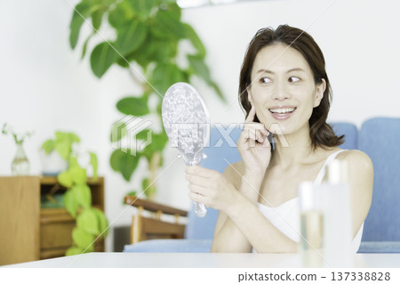 一位中年日本婦女在客廳對著鏡子微笑 137338828