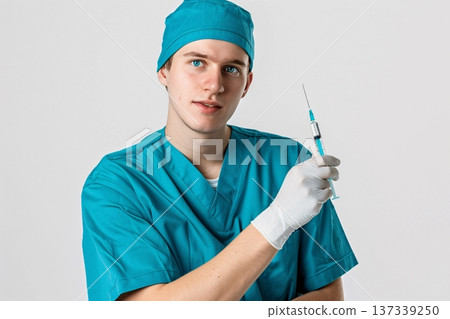 A medical professional in teal scrubs holding a syringe. Generative AI 137339250