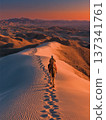 Lone Rider on Camel Traversing Sand Dunes at Sunset with Deep Tracks 137341761