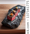 Seared A5 Wagyu Beef Cubes with Roasted Garlic on Volcanic Stone 137341775