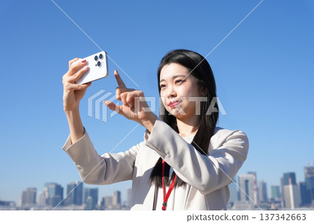 年輕女商人戶外使用智慧型手機 137342663