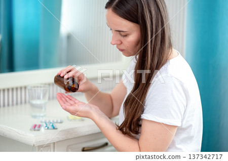 A young woman eats strawberries in the kitchen A young woman eats strawberries in the kitchen 137342717