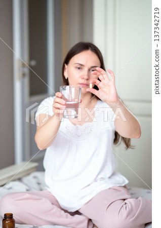 A young woman eats strawberries in the kitchen A young woman eats strawberries in the kitchen 137342719