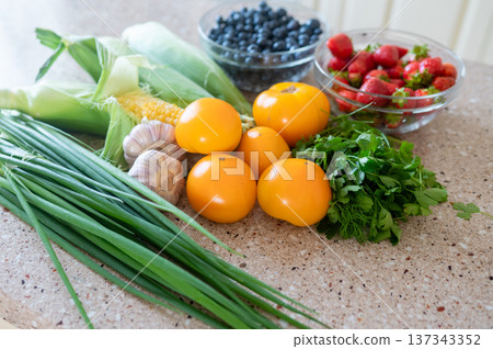 Fresh vegetables and berries on kitchen counter in natural light Fresh vegetables and berries on kitchen counter in natural light 137343352