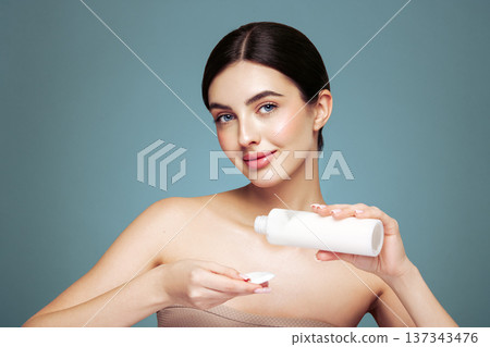Young woman cleansing face with cosmetic milk 137343476
