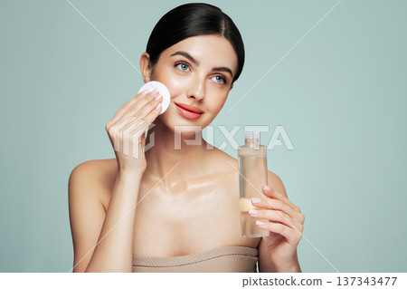 Young woman cleansing face with cosmetic milk 137343477