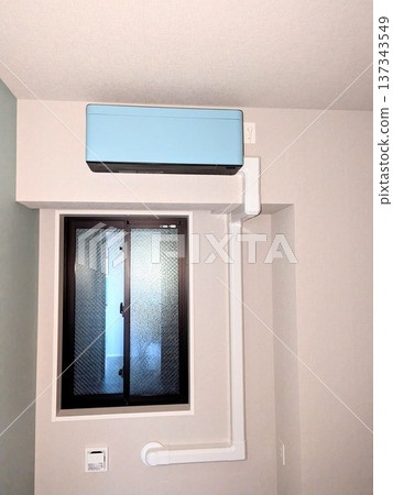 公寓大樓西式房間內安裝了一個淺藍色空調和室內管道裝飾罩。 137343549