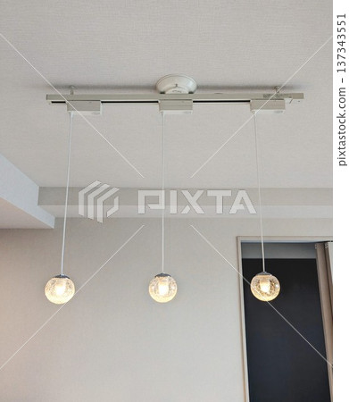 Indoor lighting with glass pendant lights hanging from a lighting rail Indoor lighting with glass pendant lights hanging from a lighting rail 137343551