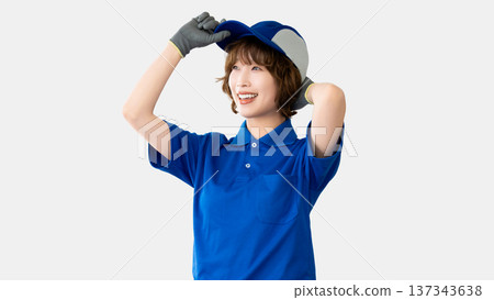 A woman in work clothes wearing a hat with a smile A woman in work clothes wearing a hat with a smile 137343638