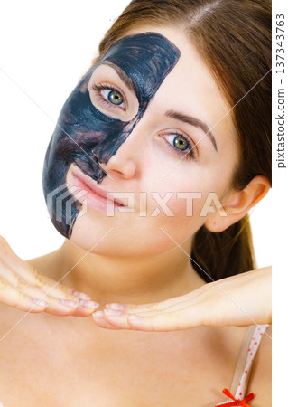 Woman with black carbo mask on face Woman with black carbo mask on face 137343763