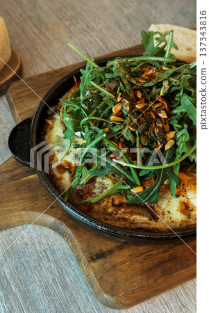 Baked eggs with arugula greens 137343816