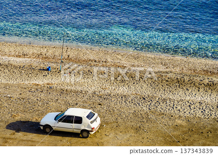 Car and fishing pole at the shore of sea. Car and fishing pole at the shore of sea. 137343839