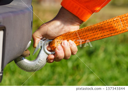 Male hand attaching towline to car Male hand attaching towline to car 137343844