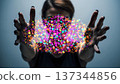 Person extends hands towards colorful sparkles on a plain background during an indoor activity at night 137344856