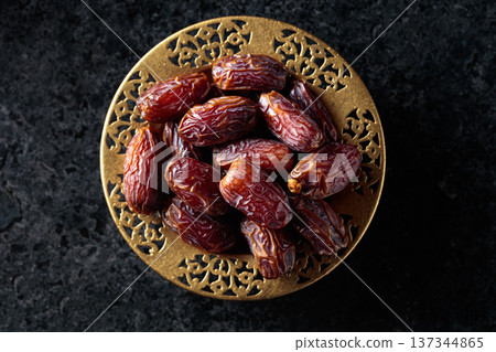 Dates fruits on black stone table. 137344865