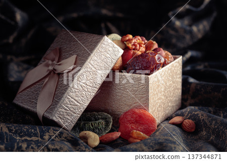 Dried tropical fruits, nuts, and raisins in gift box. Dried tropical fruits, nuts, and raisins in gift box. 137344871